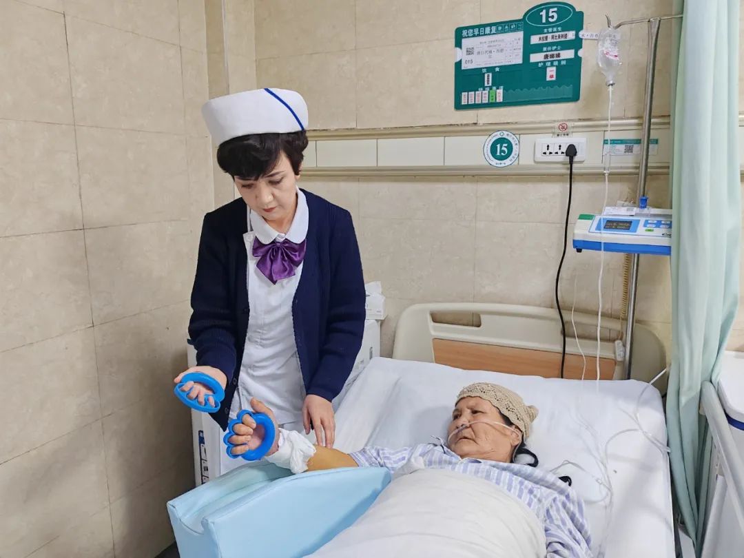 护士指导患者进行握力器应用.jpg 护士指导患者进行握力器应用.jpg